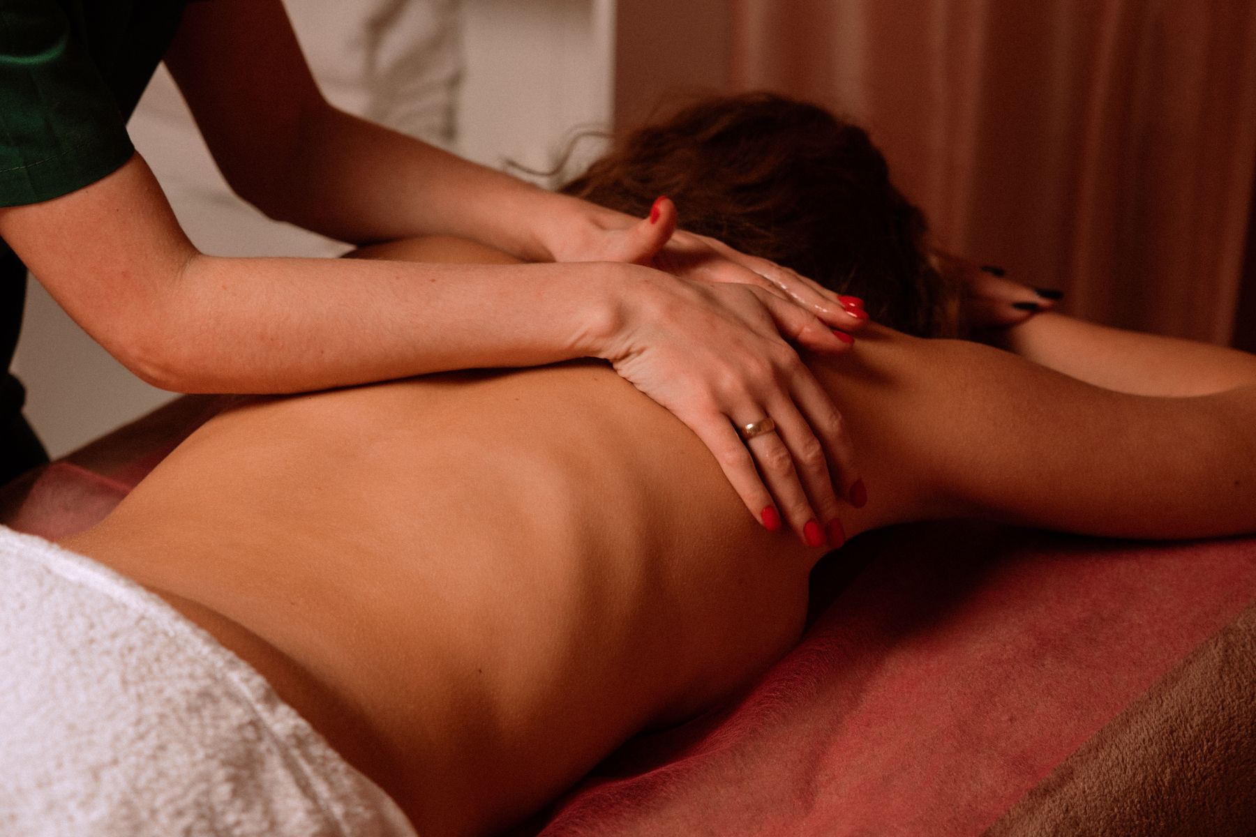 A therapist providing hands-on treatment for an adult client