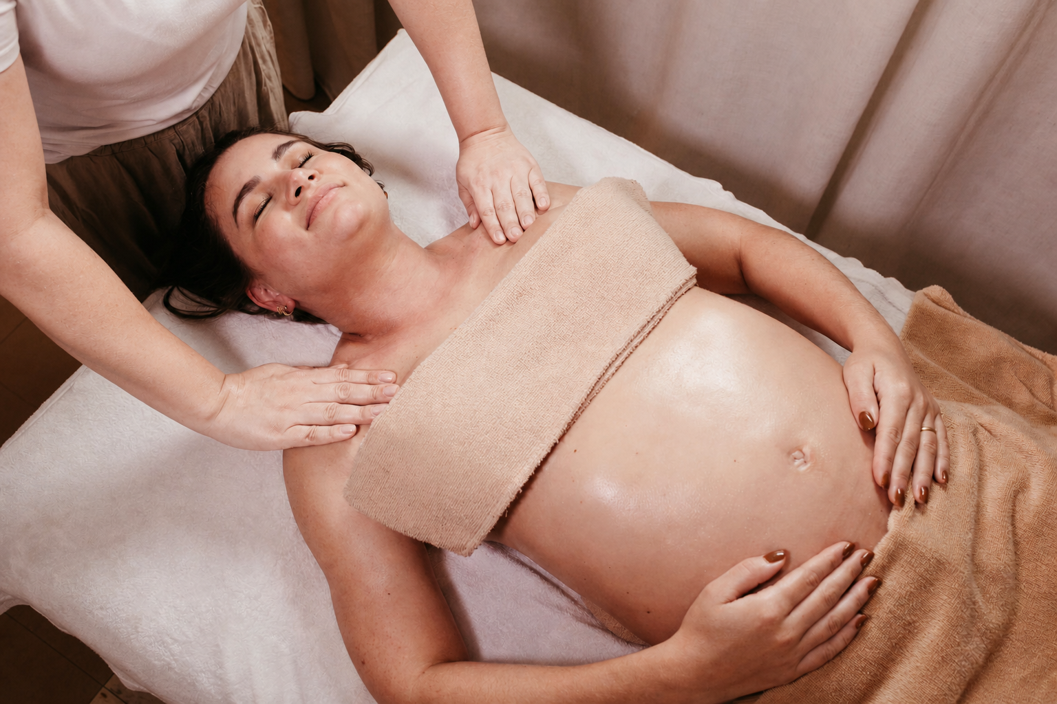 A pregnant client receiving a gentle massage treatment